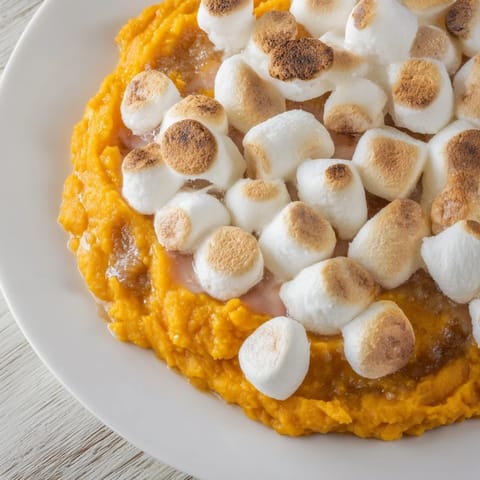 Golden sweet potato casserole topped with toasted marshmallows, a delicious holiday side dish.