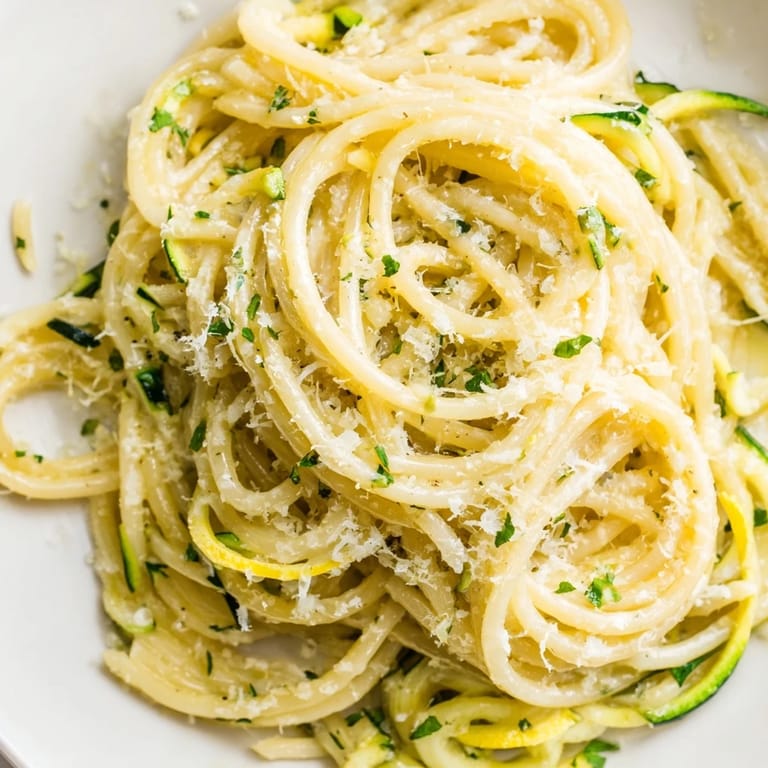 Serving a warm plate of bright Lemon Zucchini Pasta beside a glass of crisp white wine for a light summer meal.