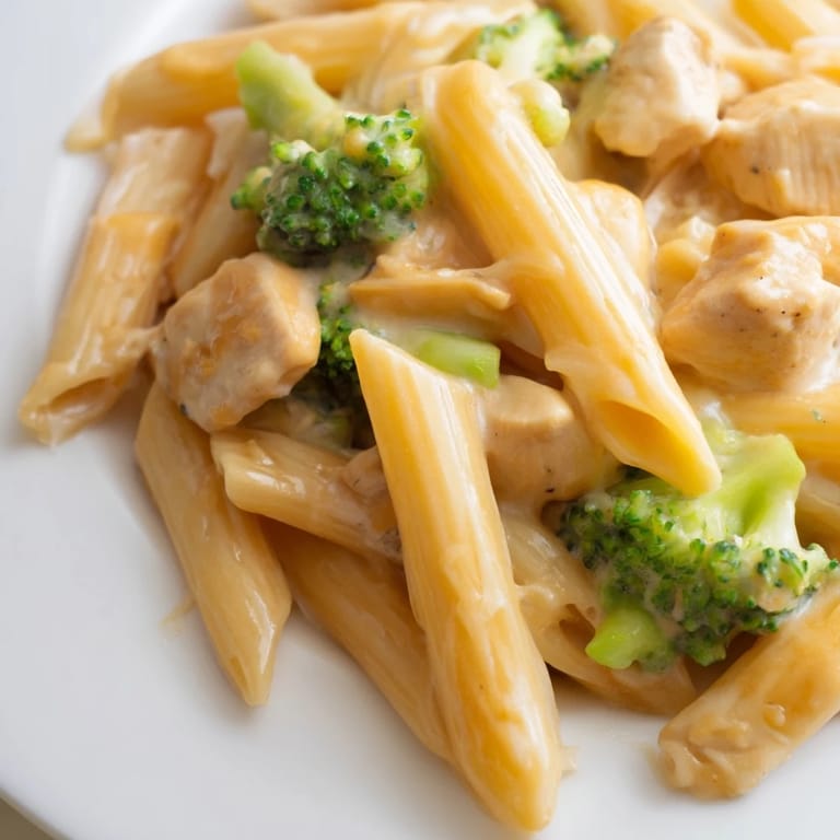 Family-style dinner plate of Chicken Broccoli Cheddar Pasta, perfect for a comforting weeknight meal with a side of garlic bread.